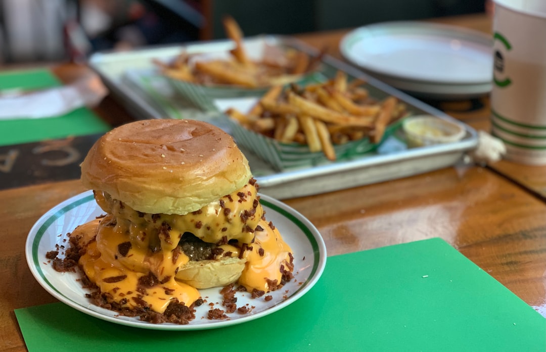 burger with patty and fries on green plate