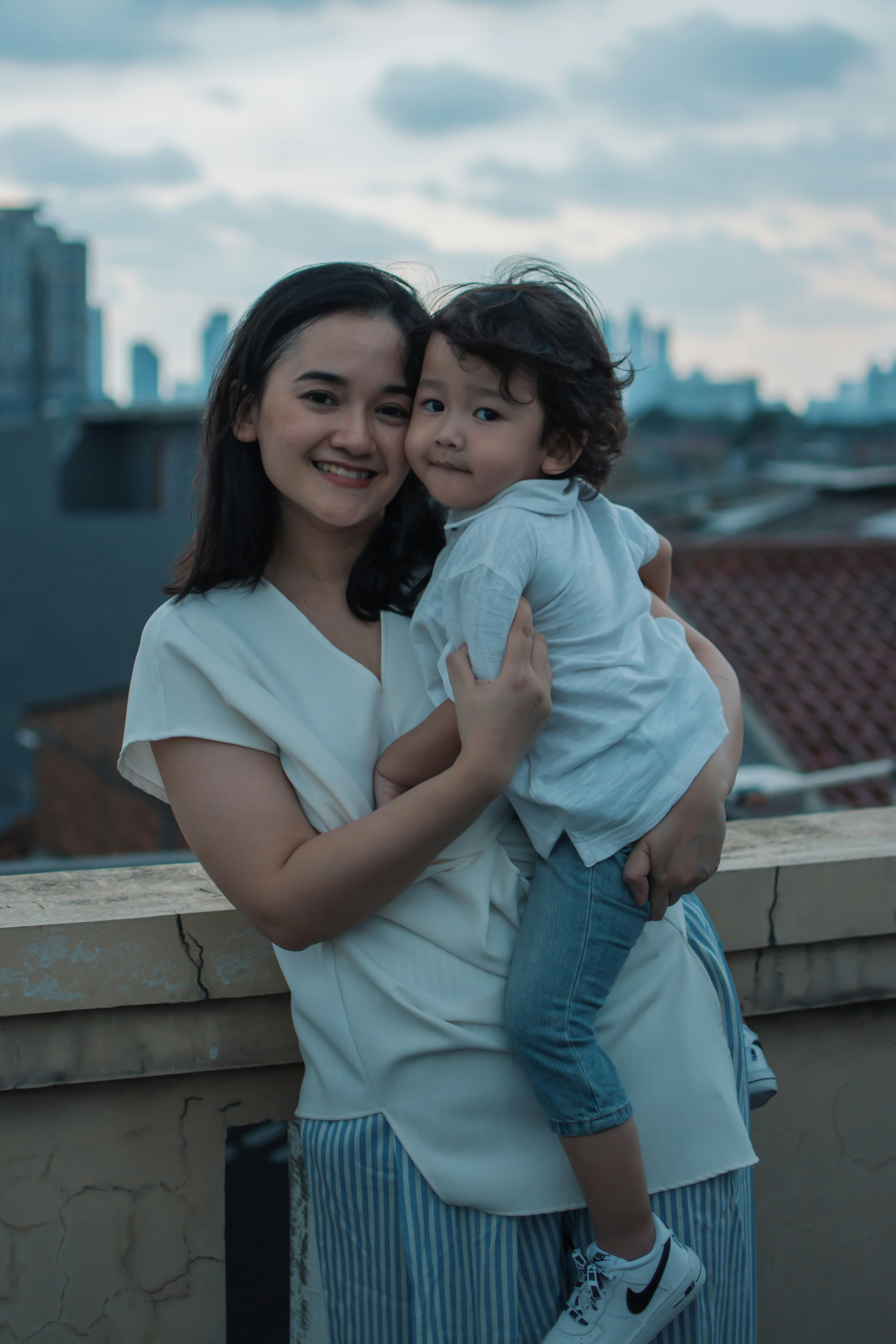 Wanita dengan kemeja putih membawa gadis dengan kemeja putih