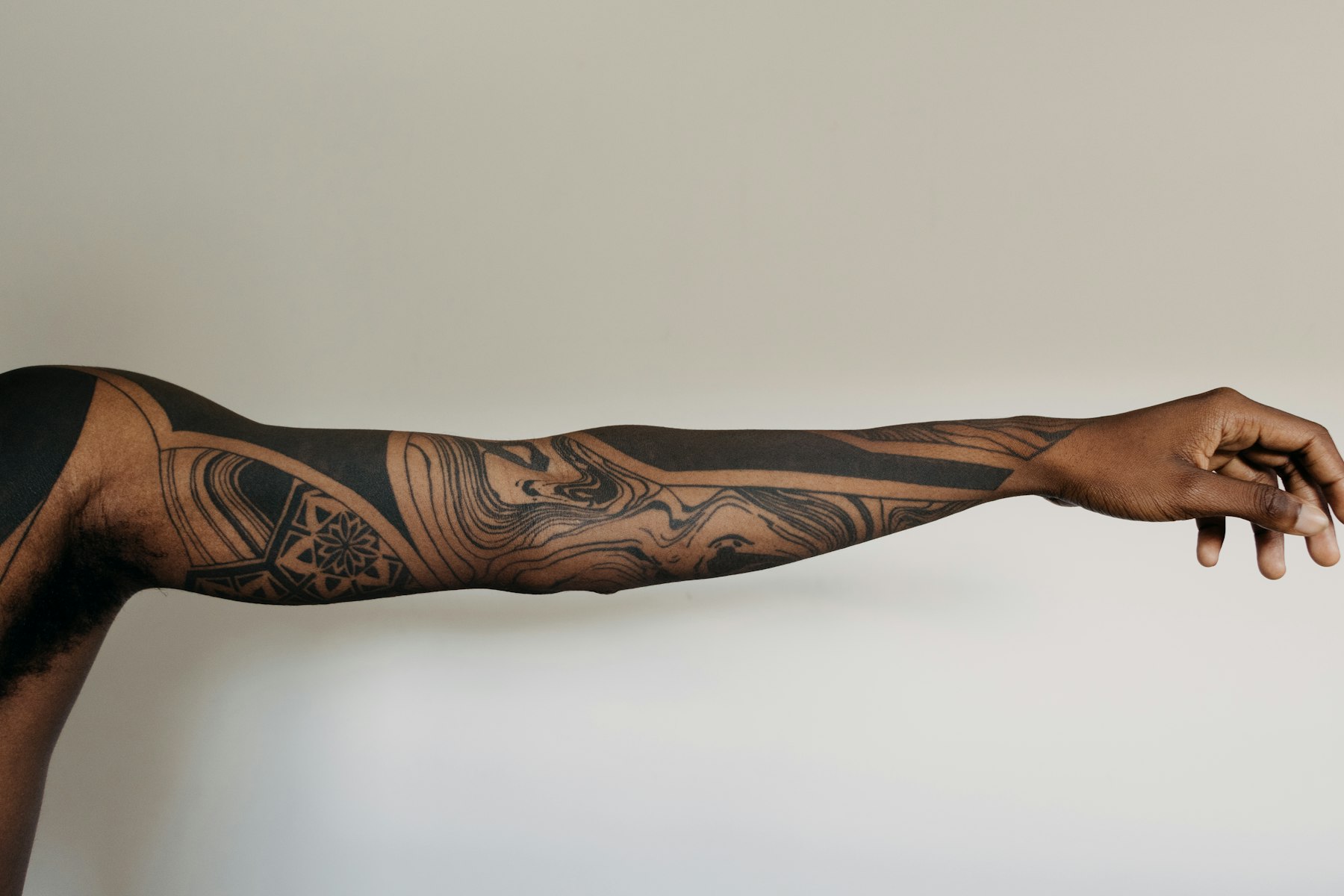 Detailed blackwork sleeve tattoo on a model's arm - Ember & Ink, New Orleans