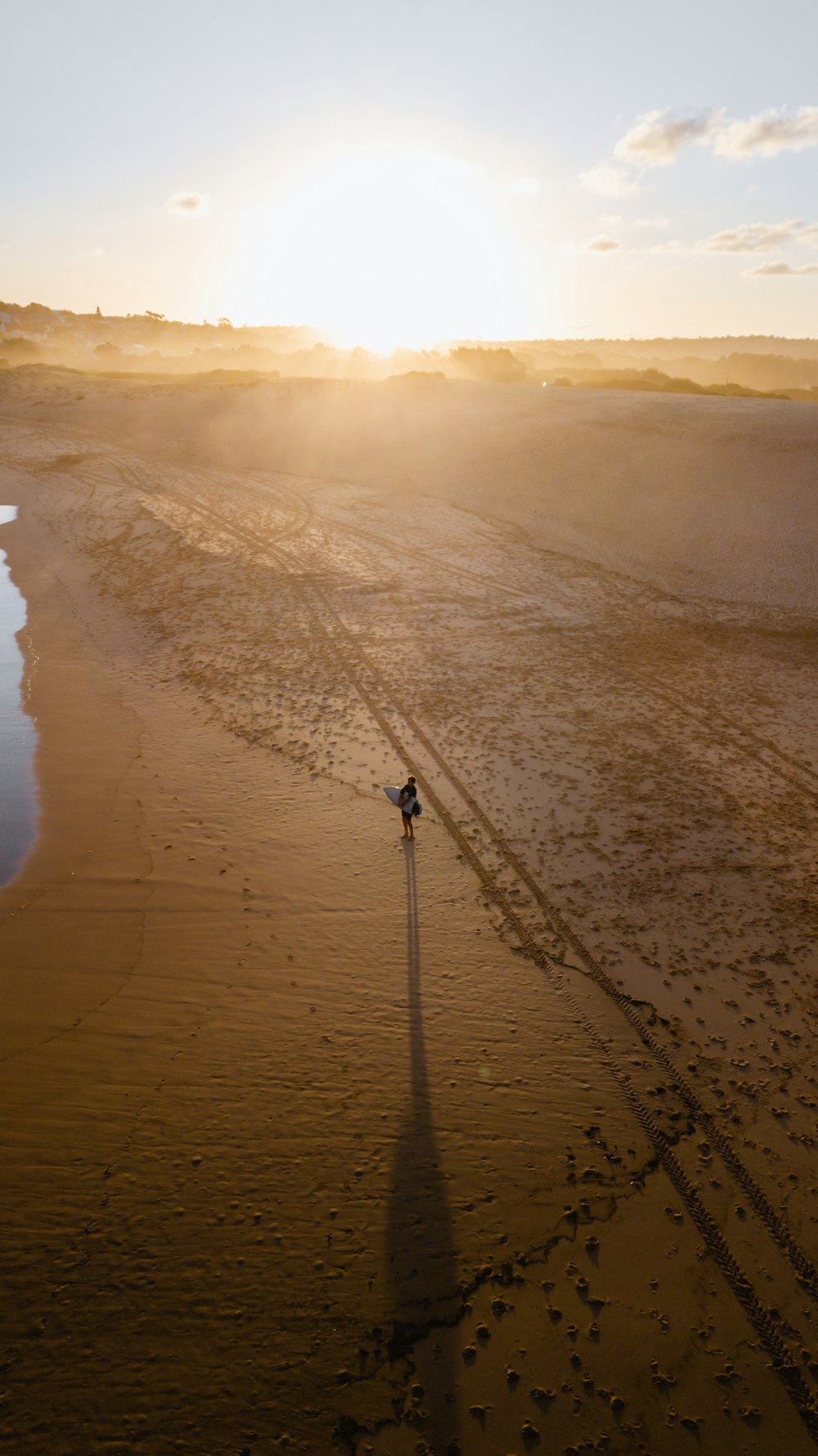 person walking on beach during sunset