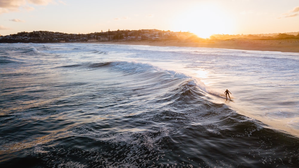 persona che fa surf sulle onde del mare durante il giorno