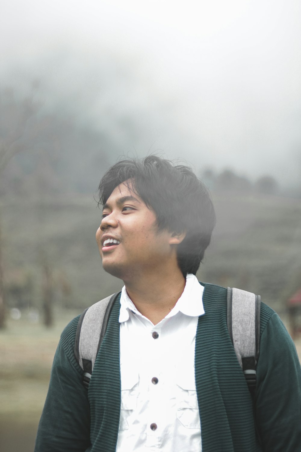 man in white shirt and green vest