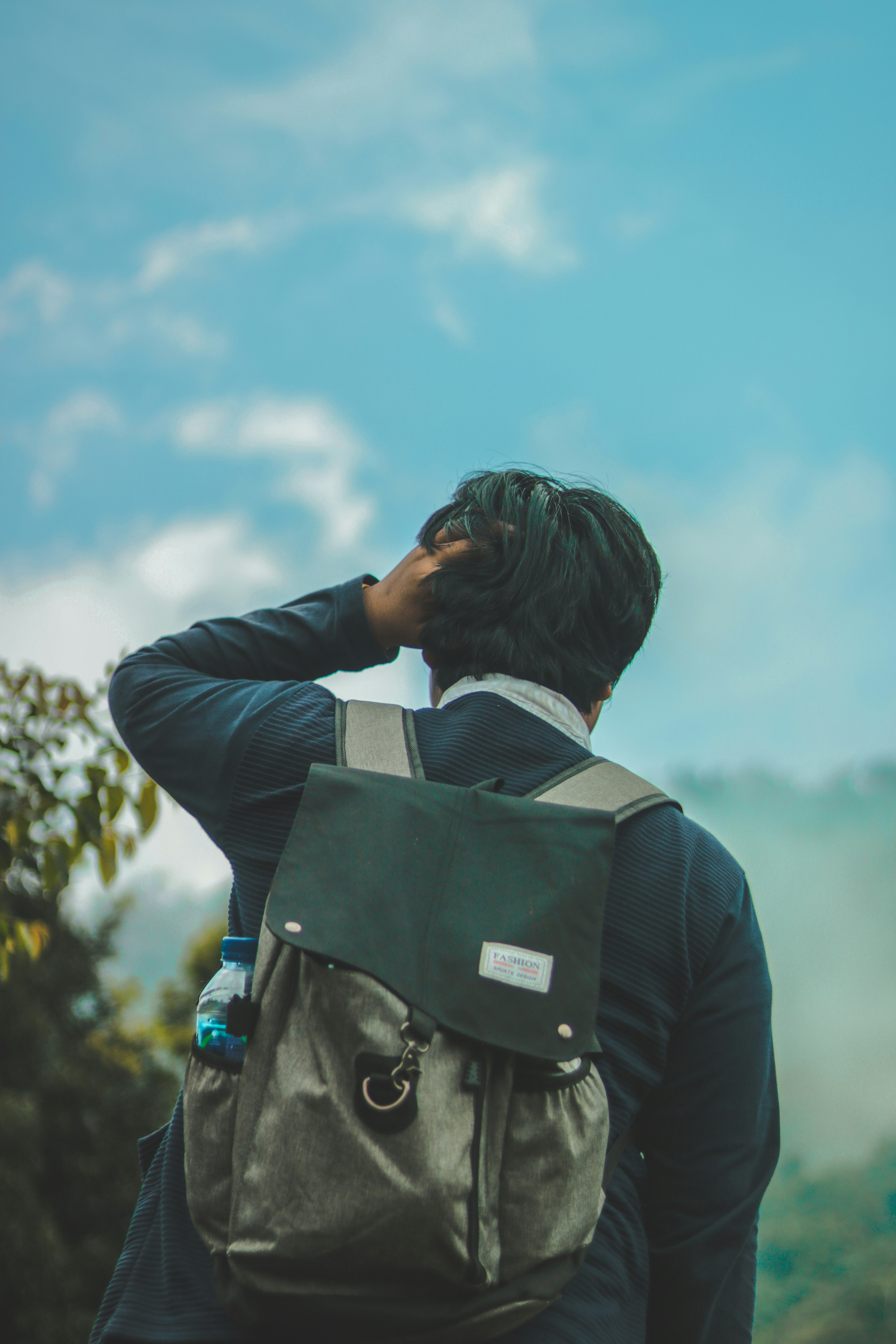 Pria berjaket hitam memegang kamera DSLR hitam