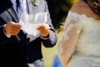 man in black suit holding womans hand