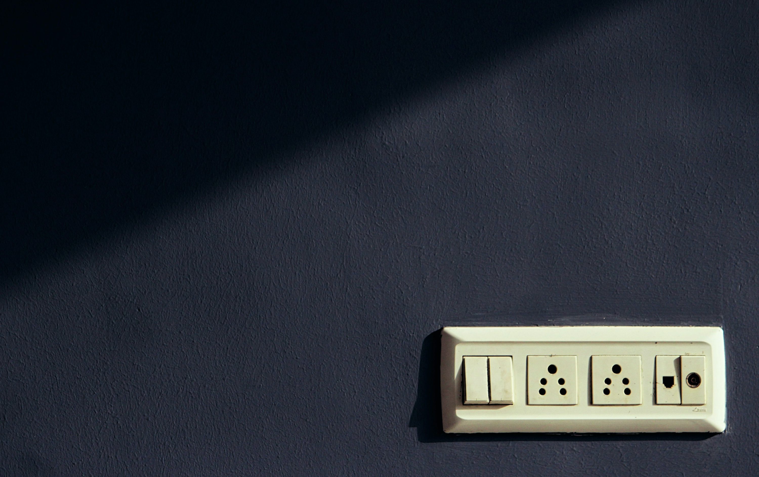 茶色の壁に白い壁に取り付けられたスイッチ