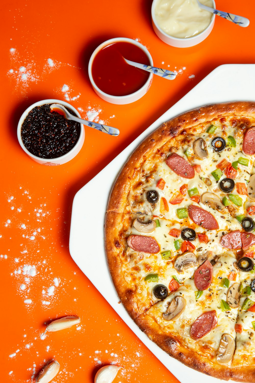 Pizza con pepperoni y queso en la mesa de naranja