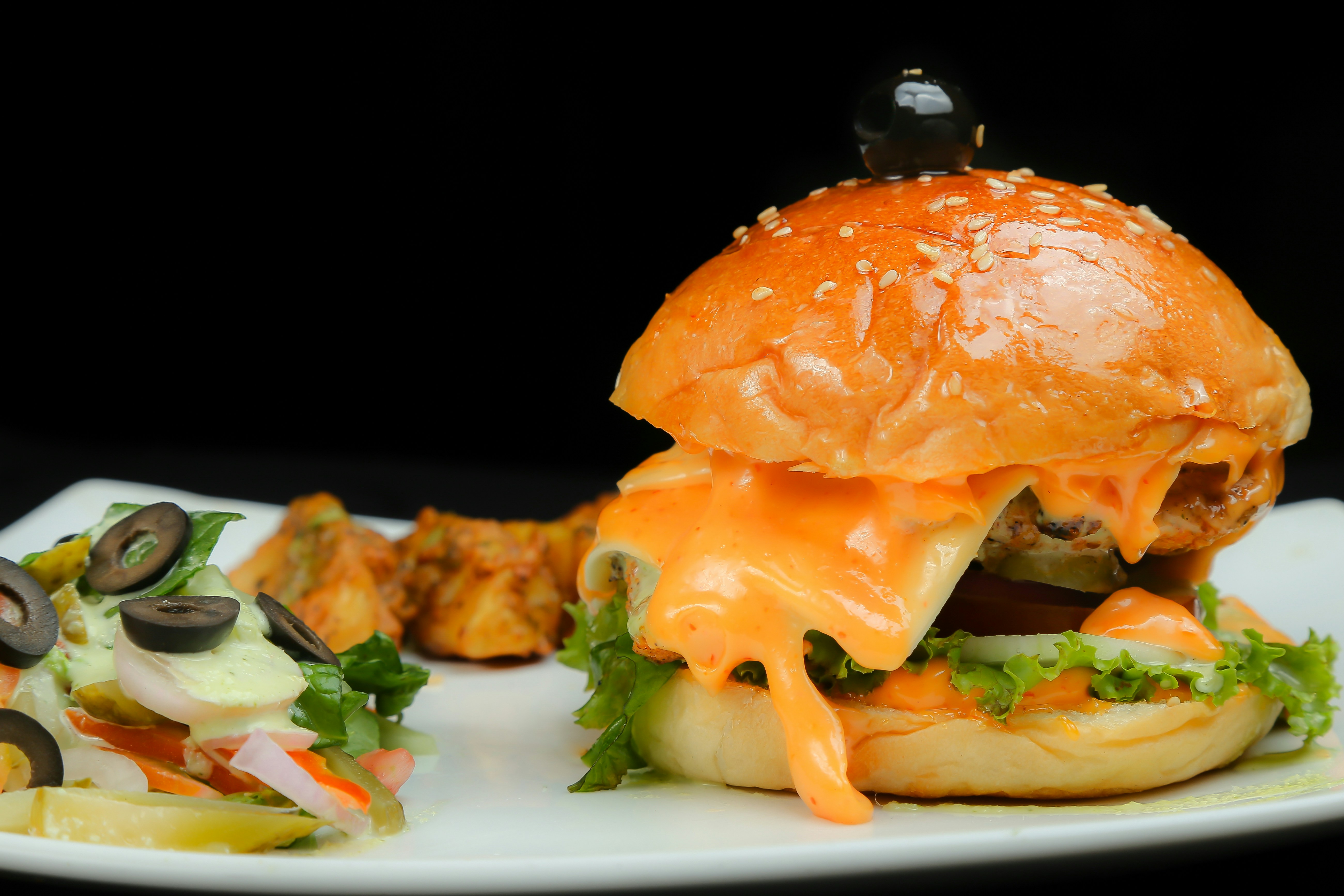Chicken burger with cheese sauce on a plate