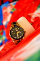 A black Invicta watch showcased against a vibrant background.