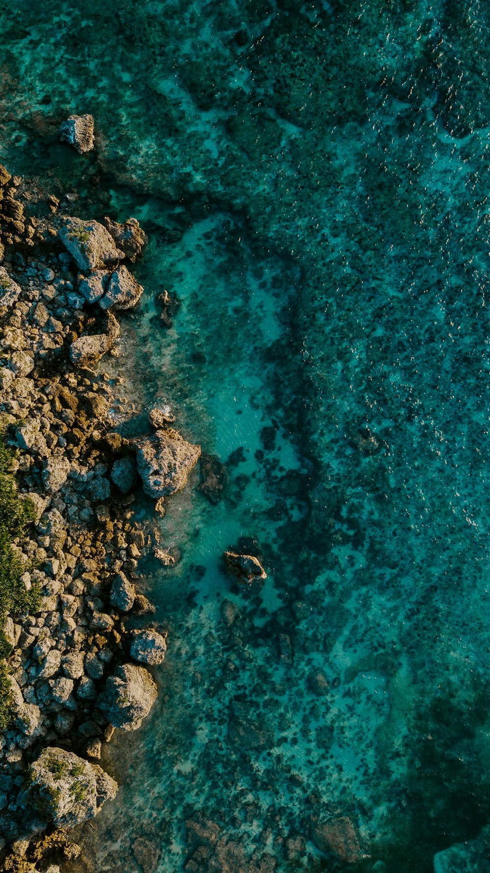 brown and black rocks on body of water