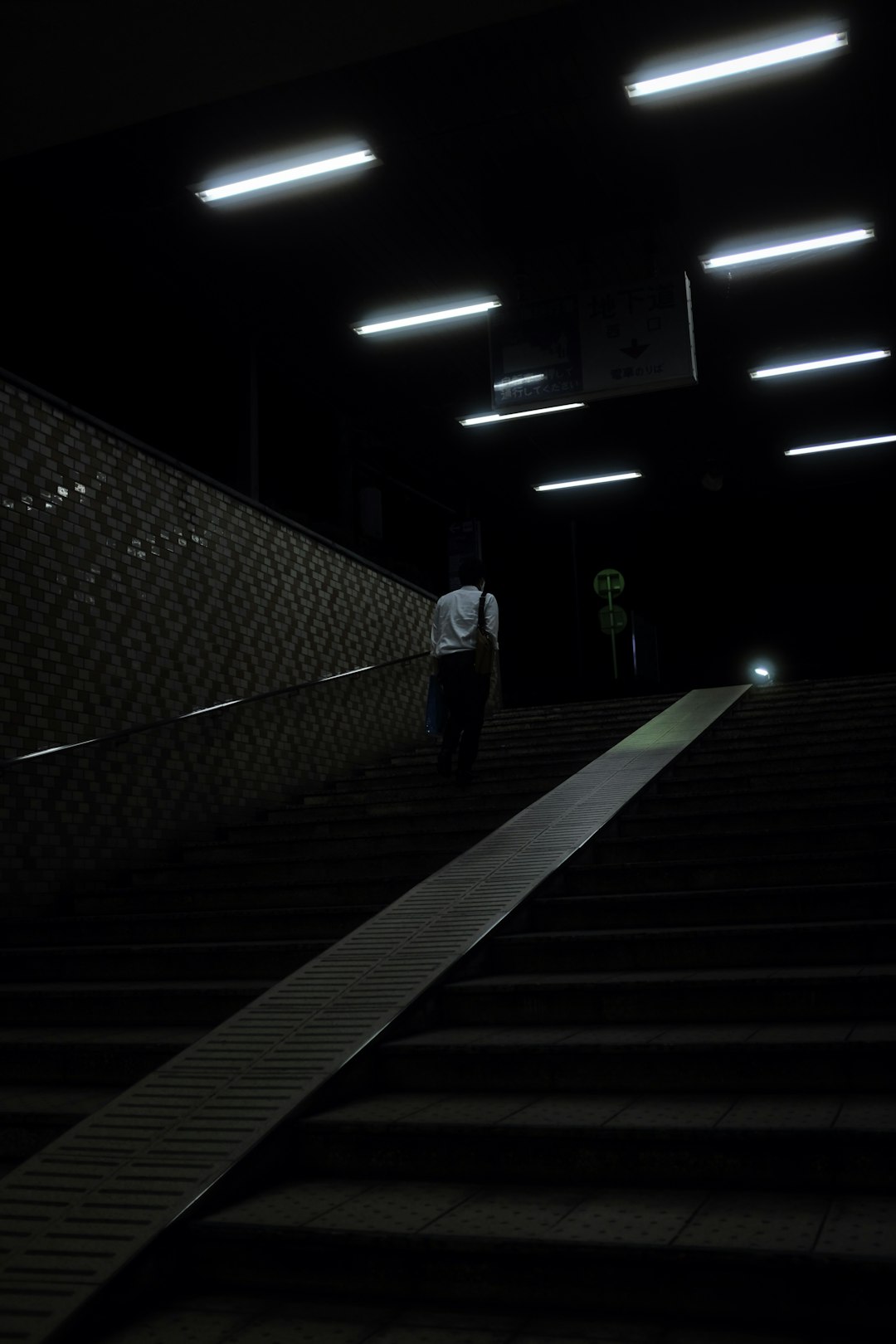 man in black jacket walking on the stairs