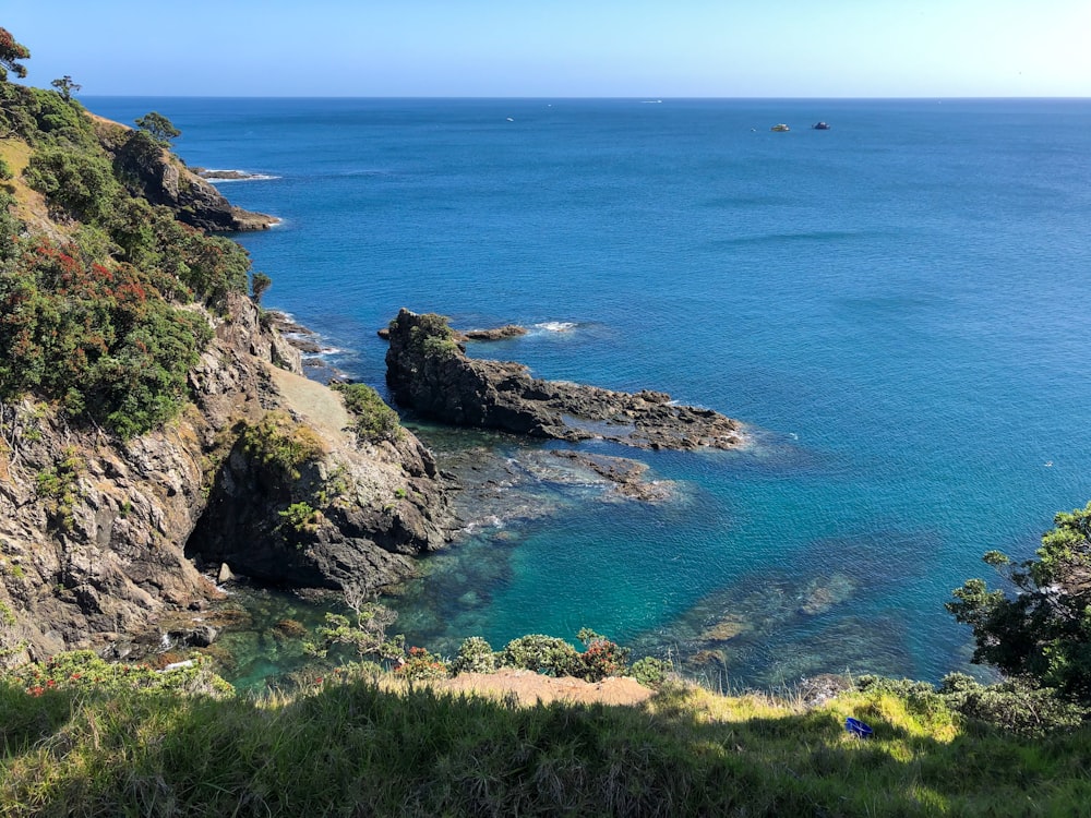 green and brown rock formation beside blue sea during daytime