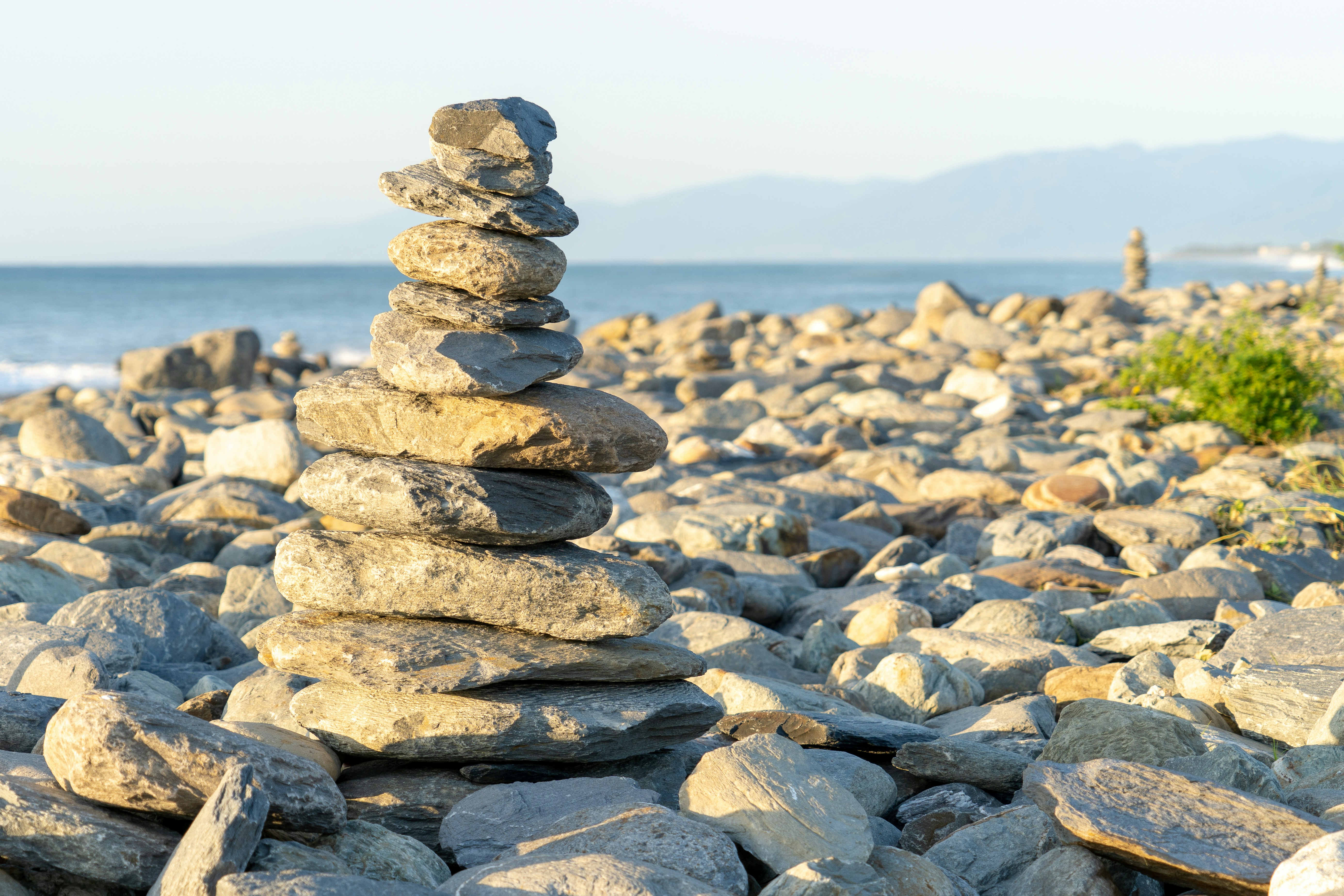 stack of stones near body of water during daytime