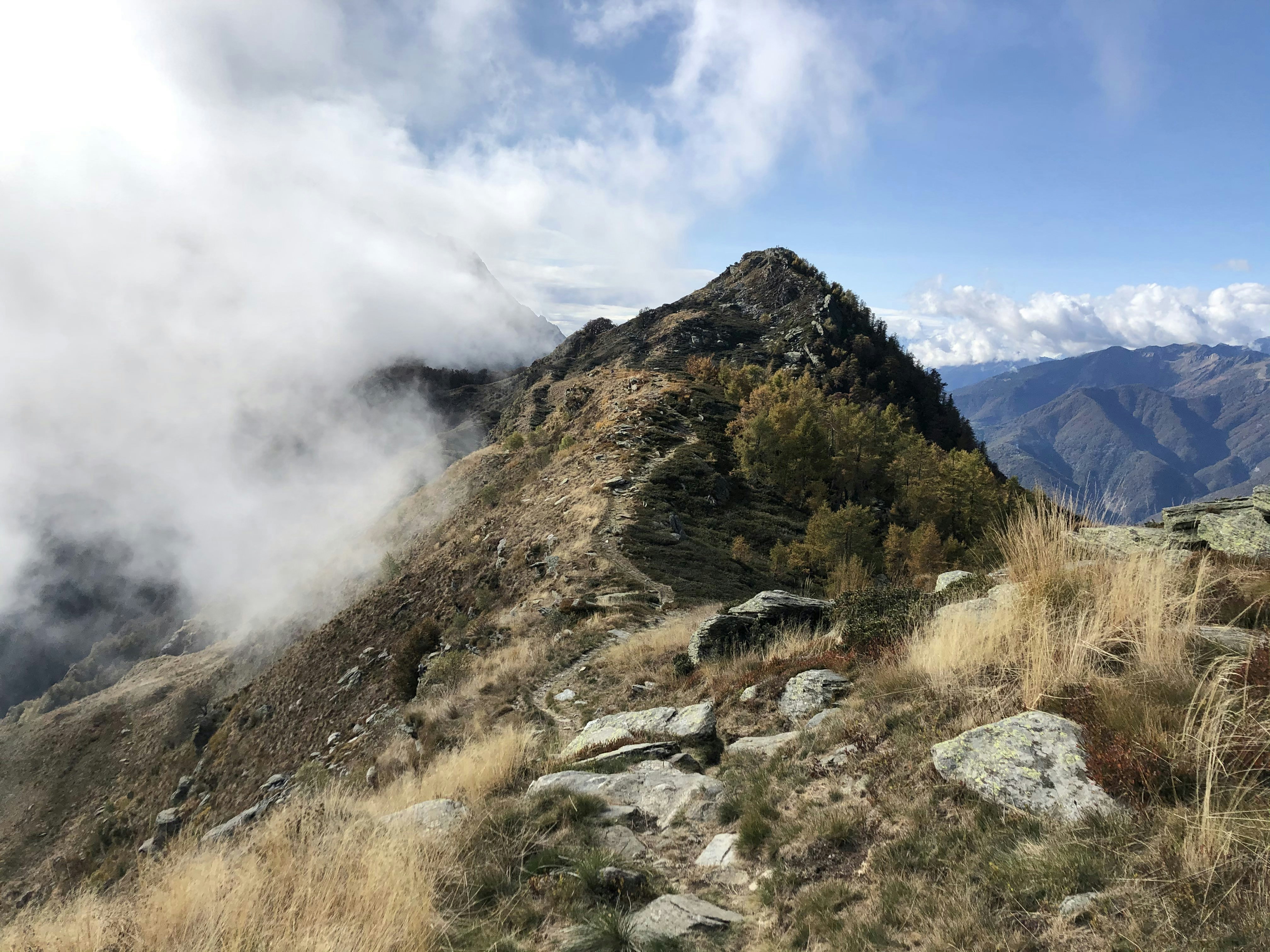 green and brown mountain under white clouds and blue sky during daytime | Houfy — Book Direct