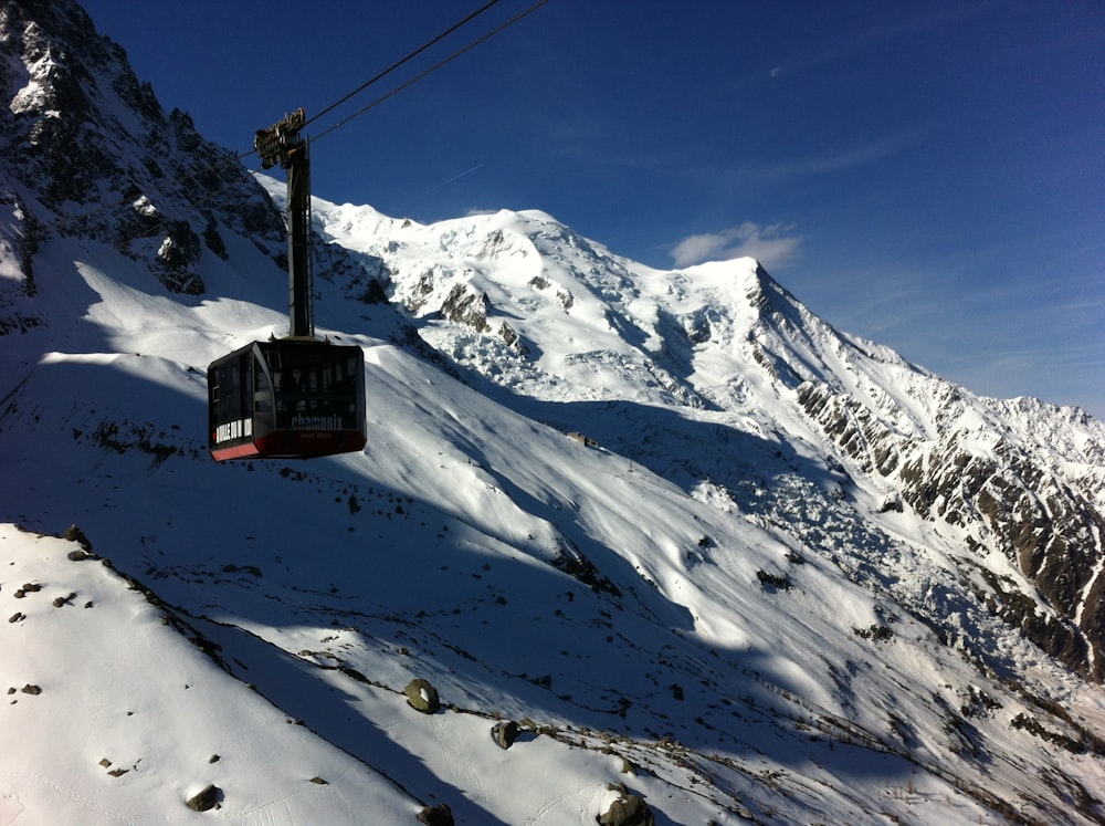 red cable car over snow covered mountain