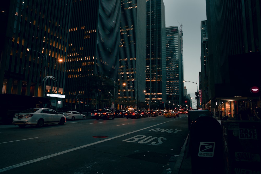 cars on road near high rise buildings during night time