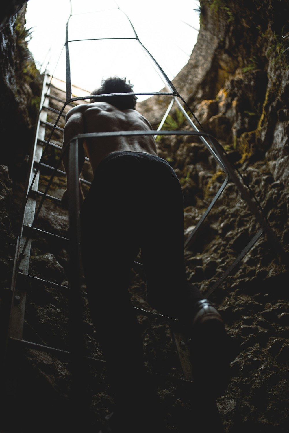 man in black pants walking down the stairs