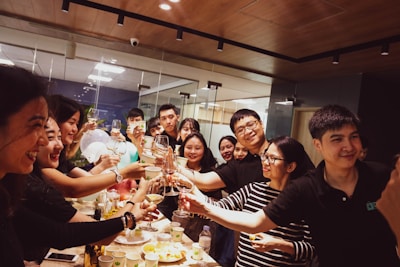 A group of happy employees wearing glasses, smiling in an office environment.