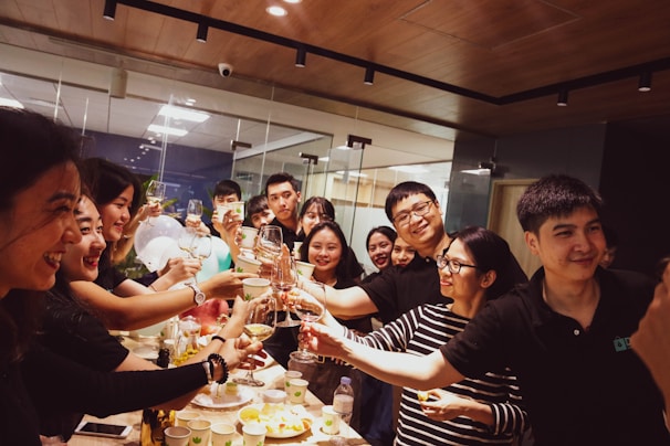 A group of happy mentees celebrating their scholarship awards with their mentors in a bright, modern office.