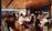 A diverse group of people smiling and sharing feedback in a bright, modern office space.