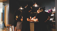 Students laughing and learning together around a warm kitchen island filled with spices.