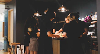 A group of friendly housemates chatting around a kitchen island.