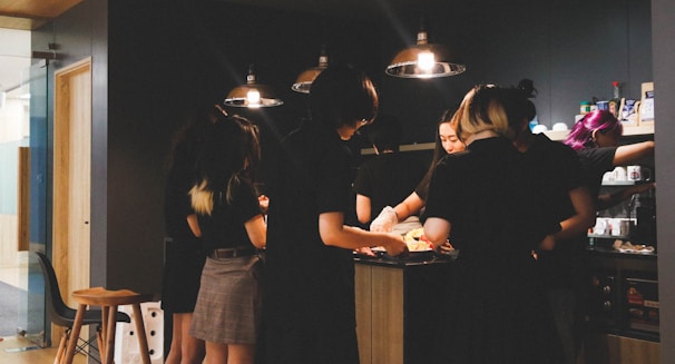 A group of kids chopping vegetables and engaging lively around a kitchen island.
