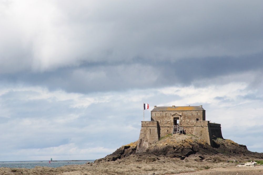 brown concrete building on brown rock formation under white clouds during daytime