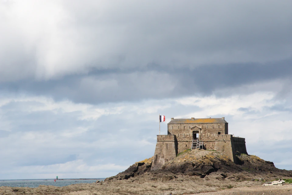 Small island fortress at low tide, similar to Fort Pâté in the Gironde estuary