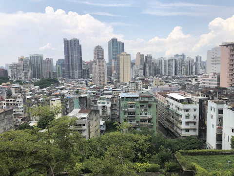 A dense urban jungle blending skyscrapers with lush green foliage under a cloudy sky.