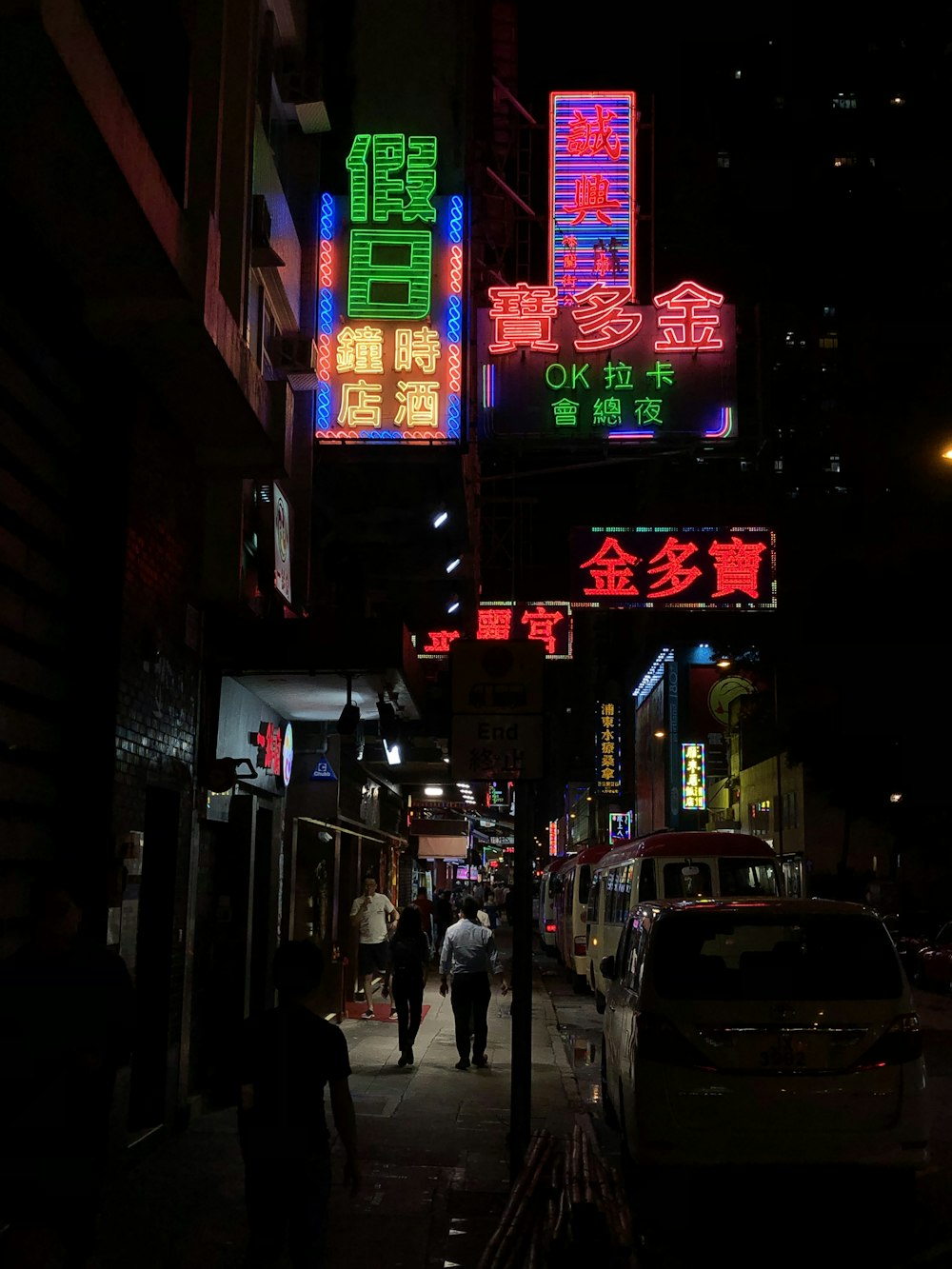 people walking on sidewalk during night time