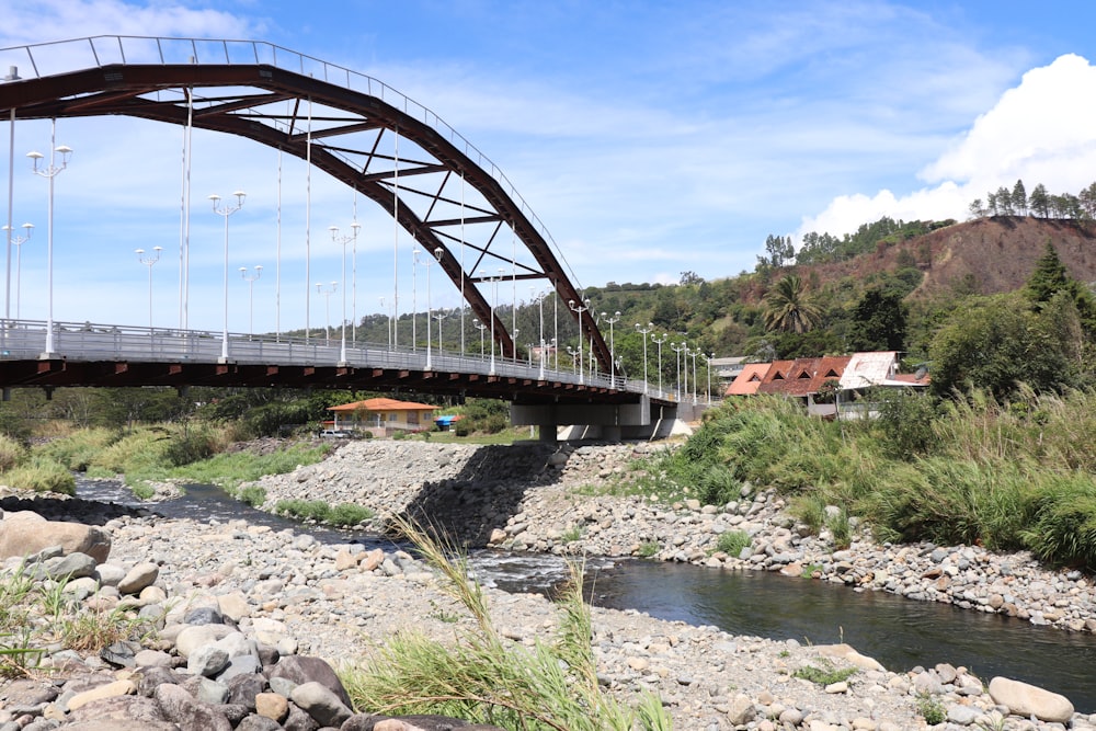 gray bridge over river under blue sky during daytime