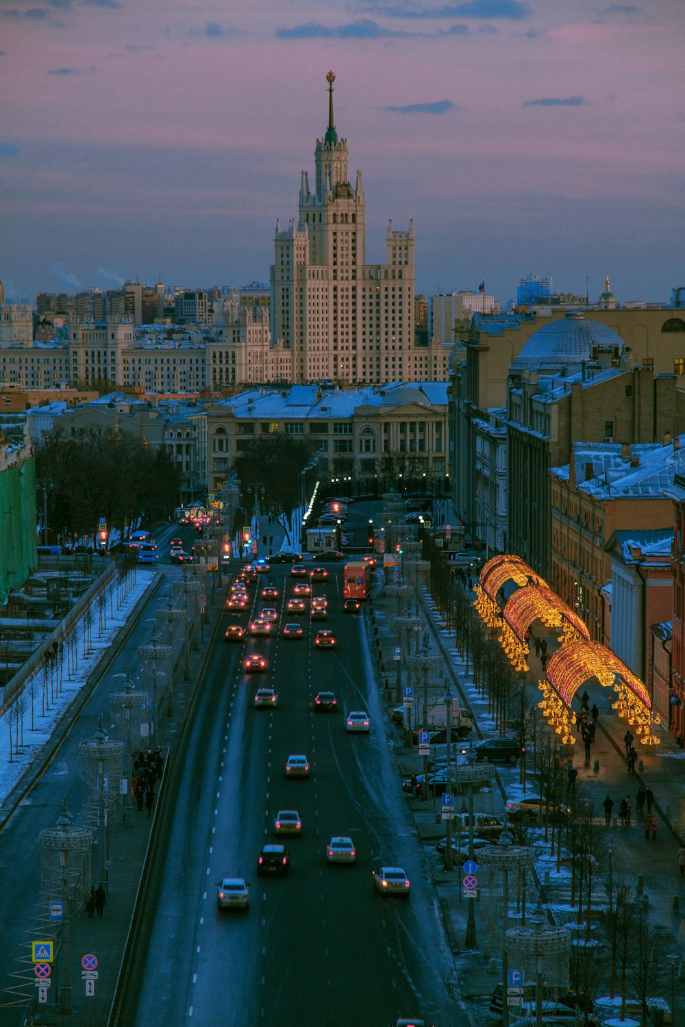 cars on road near city buildings during night time