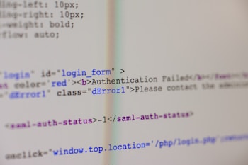 A close-up view of HTML code on a computer screen includes a login form with an error message indicating 'Authentication Failed'. The text has some parts styled in red, signifying an error or warning message.