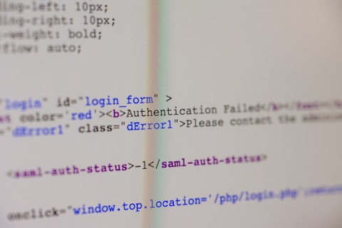 A close-up view of HTML code on a computer screen includes a login form with an error message indicating 'Authentication Failed'. The text has some parts styled in red, signifying an error or warning message.