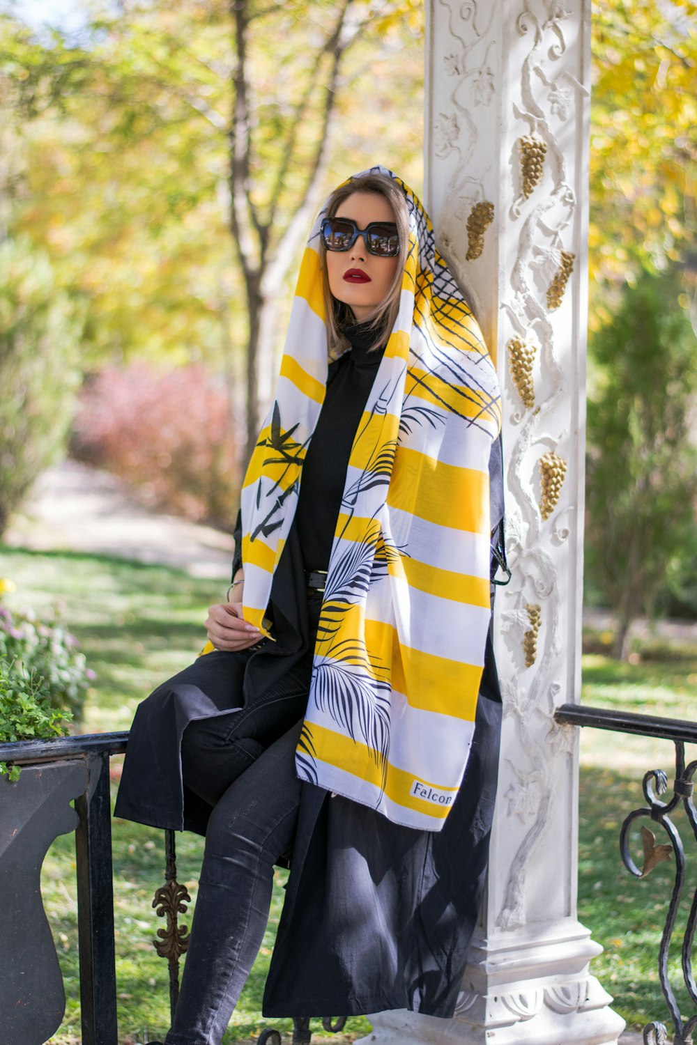 woman in black long sleeve shirt and white yellow and blue hijab sitting on black metal