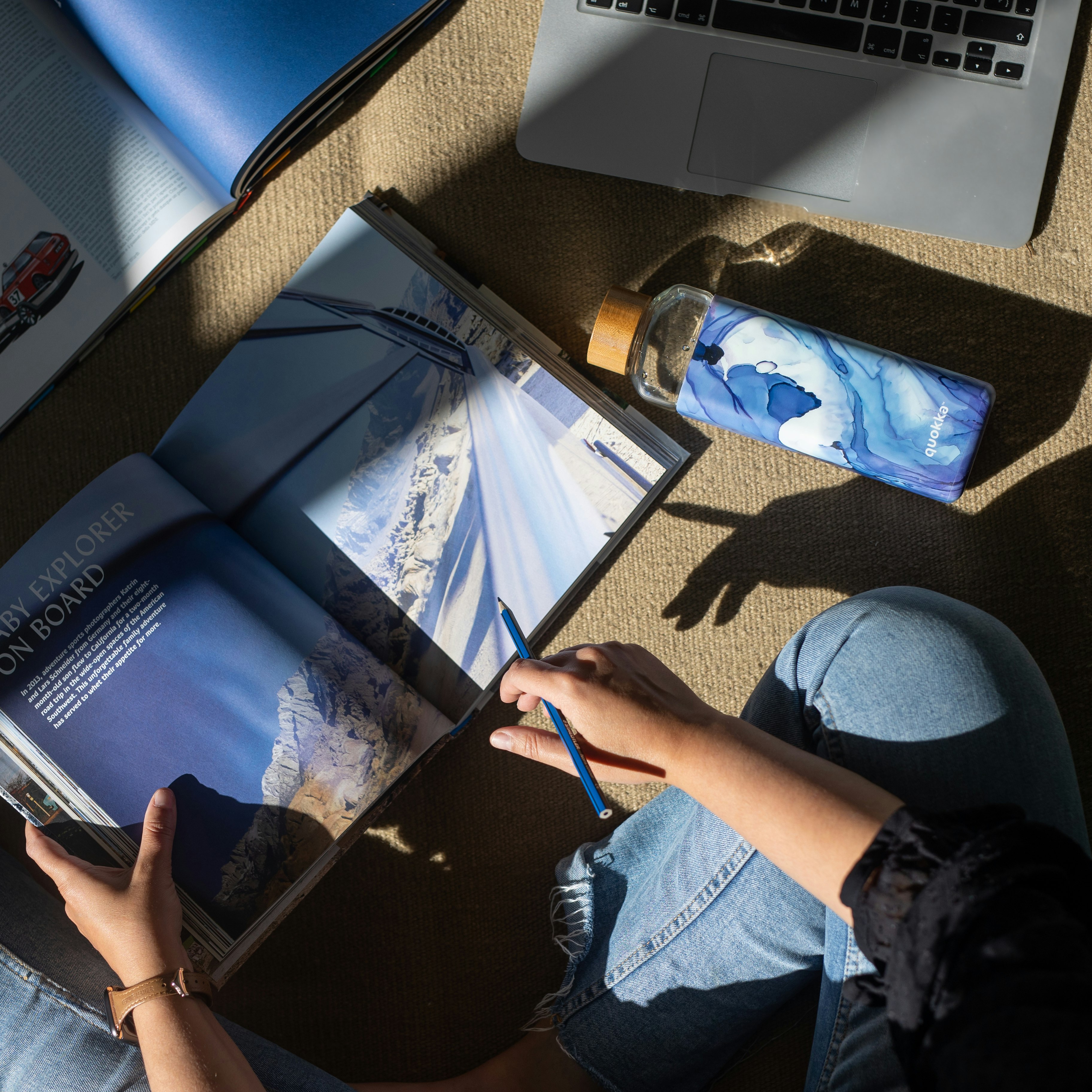 person in blue denim jeans holding blue pen