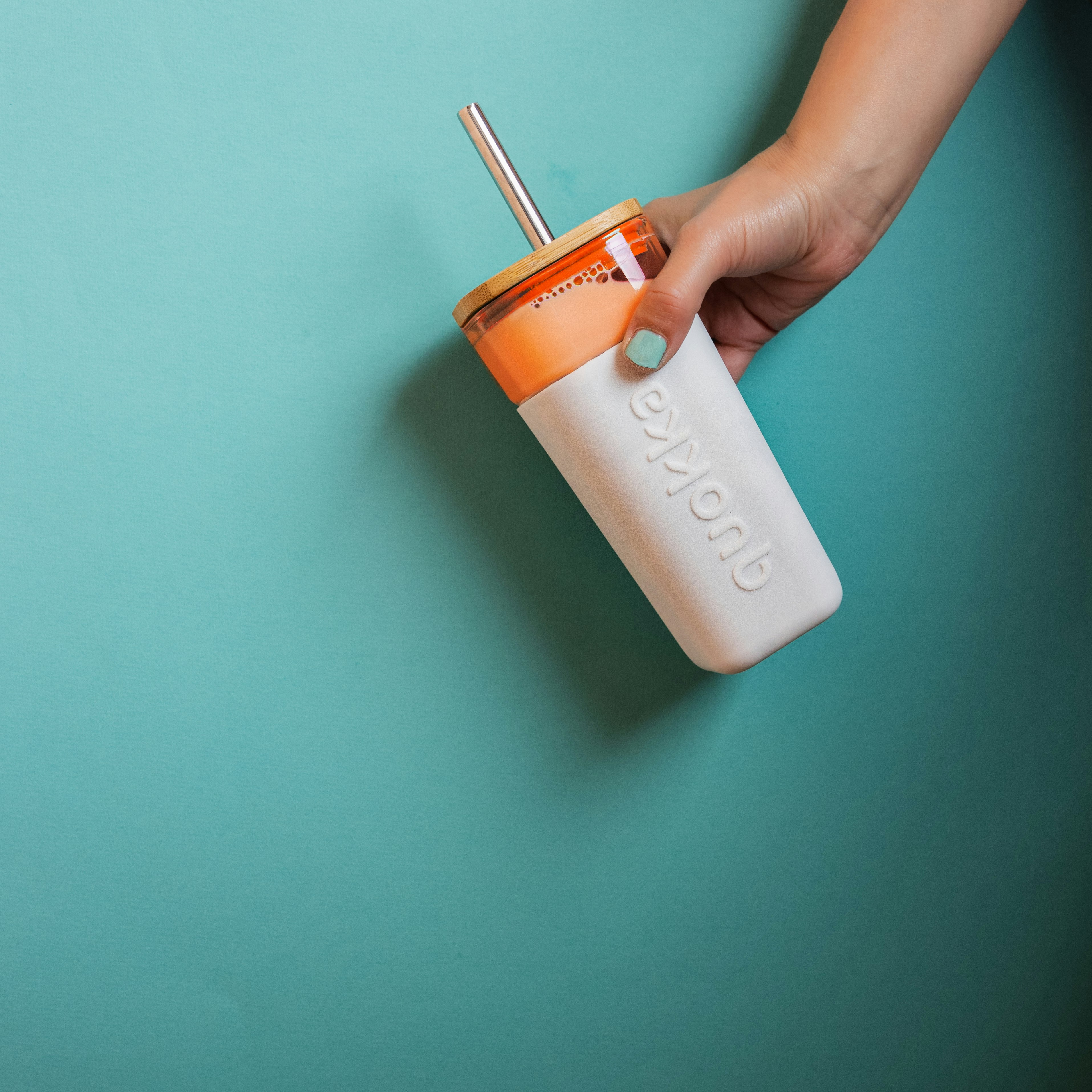 person holding white and orange plastic bottle