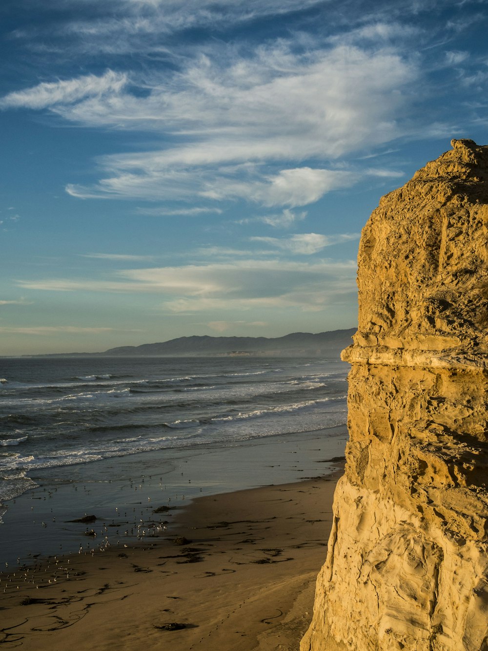 brown rock formation near body of water during daytime