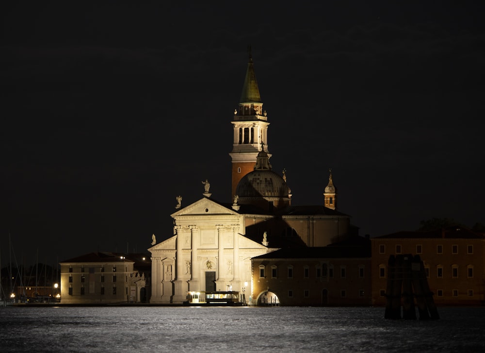 white concrete building near body of water during night time