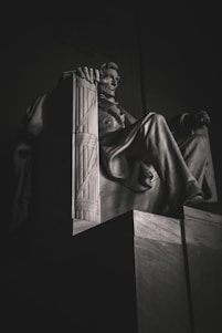 man in robe statue in grayscale photography