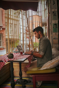 Happy small business owner using a laptop in a cozy café setting