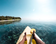person sitting on white chair near body of water during daytime