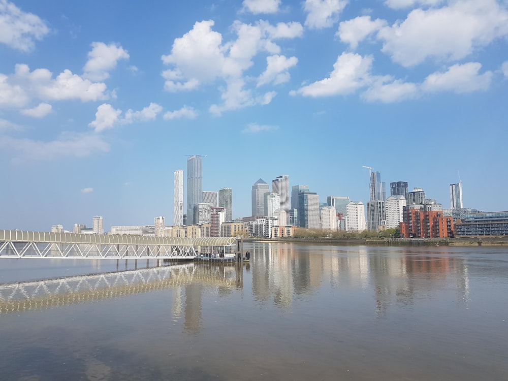 city skyline across body of water under blue and white sunny cloudy sky during daytime