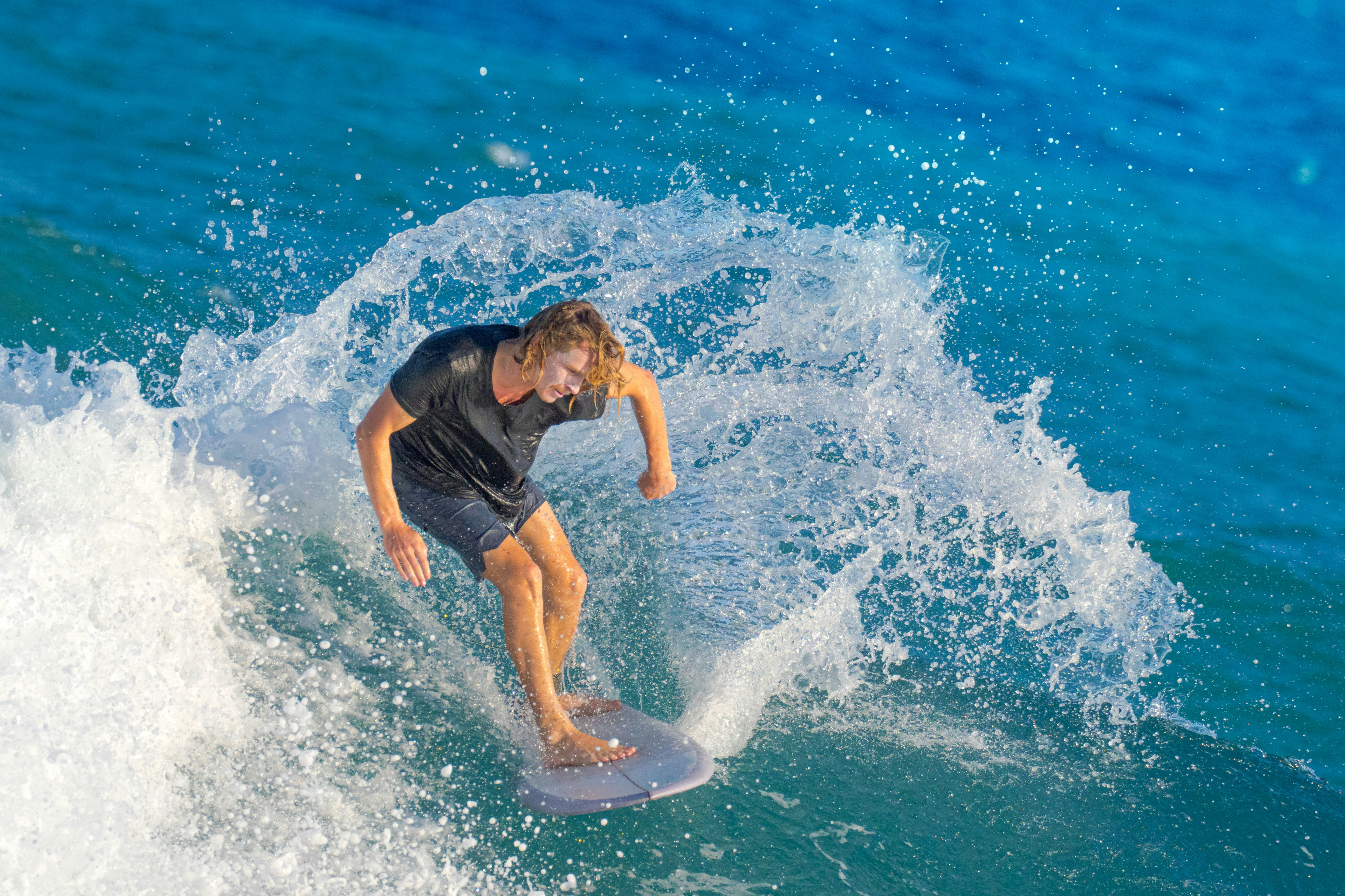 昼間に水でサーフィンをする黒いシャツを着た男の写真 Unsplashで見つける海洋の無料写真