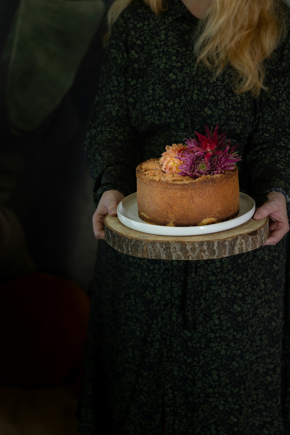 woman holding brown and white cake