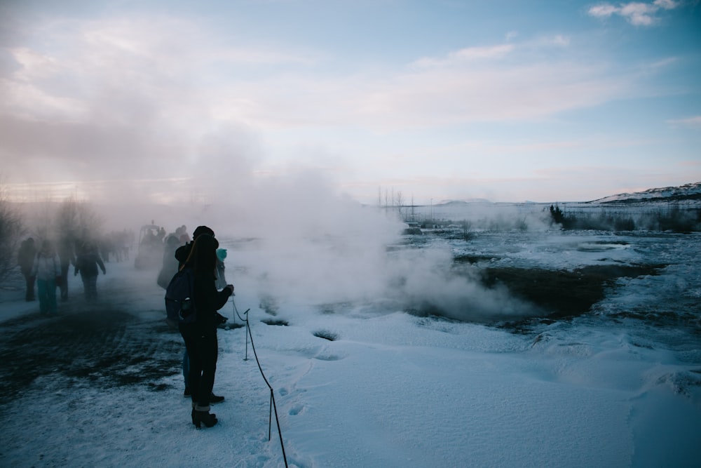 man in black jacket and black pants standing on snow covered ground