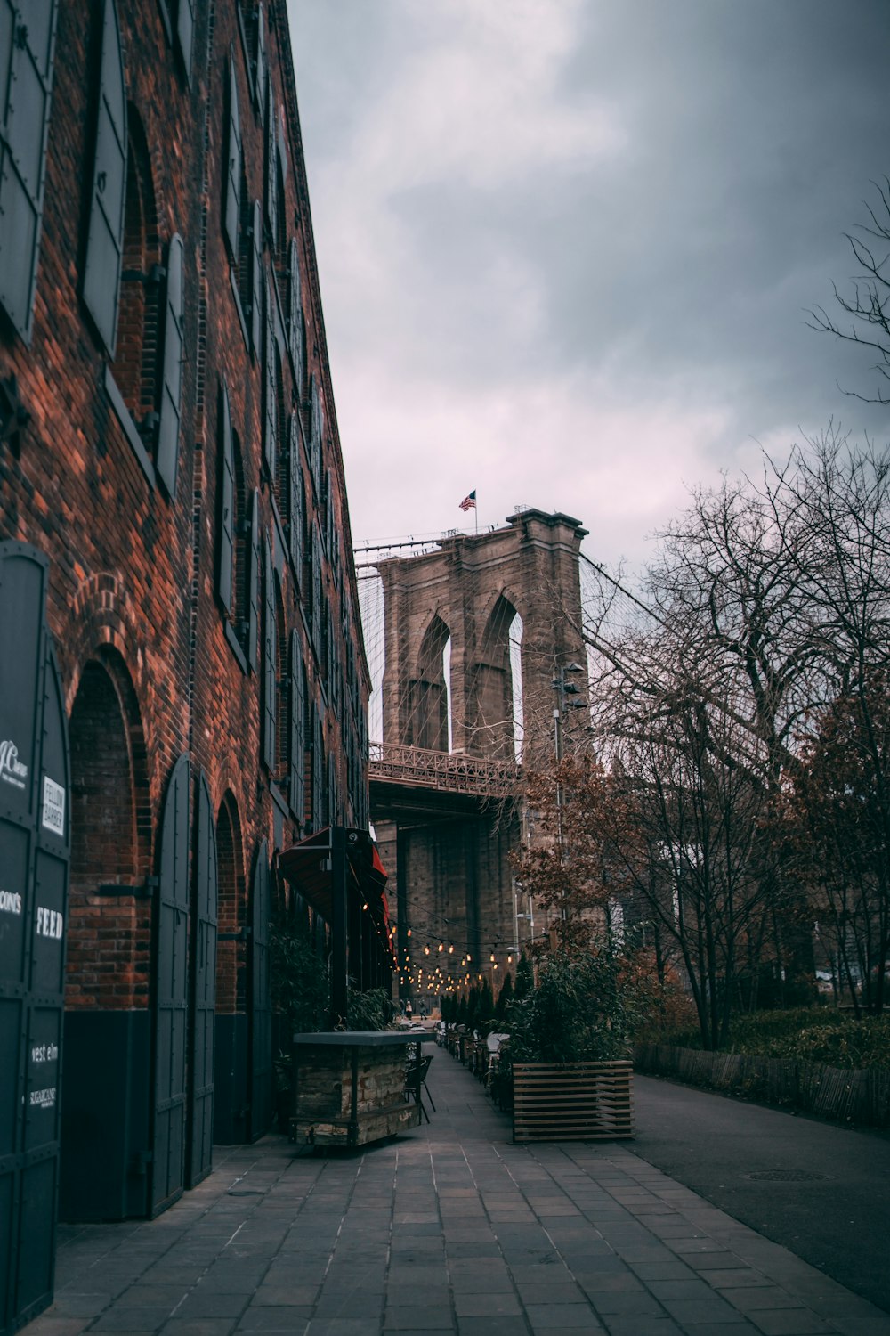 brown brick building near bare trees under cloudy sky during daytime