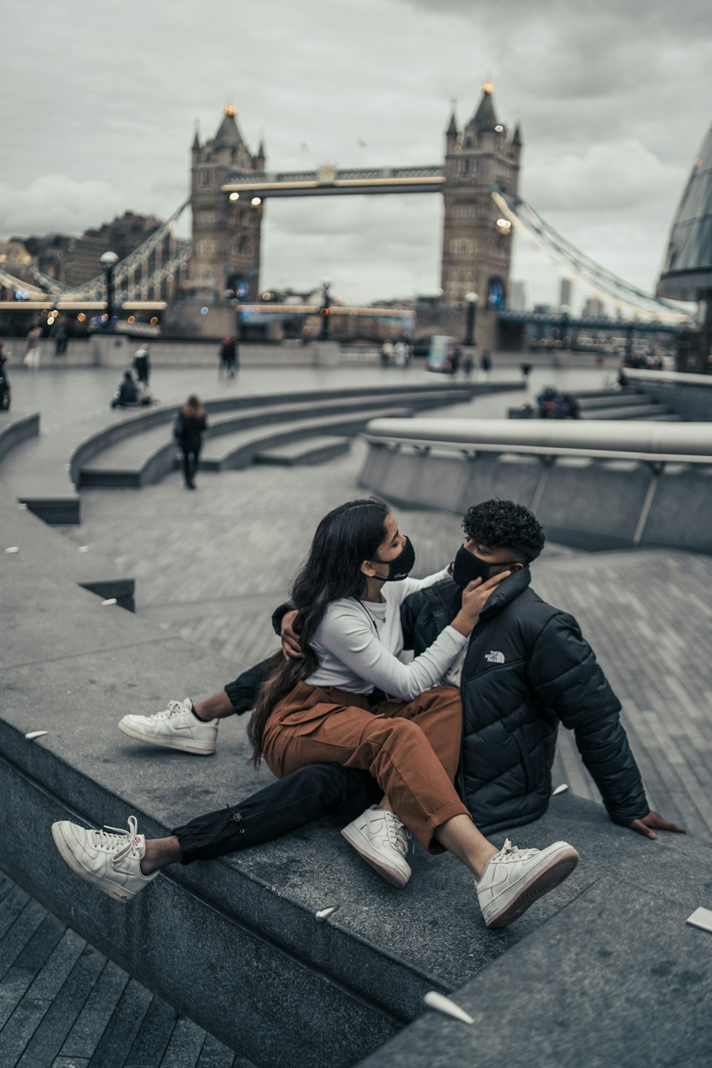 man in black leather jacket sitting beside woman in white long sleeve shirt