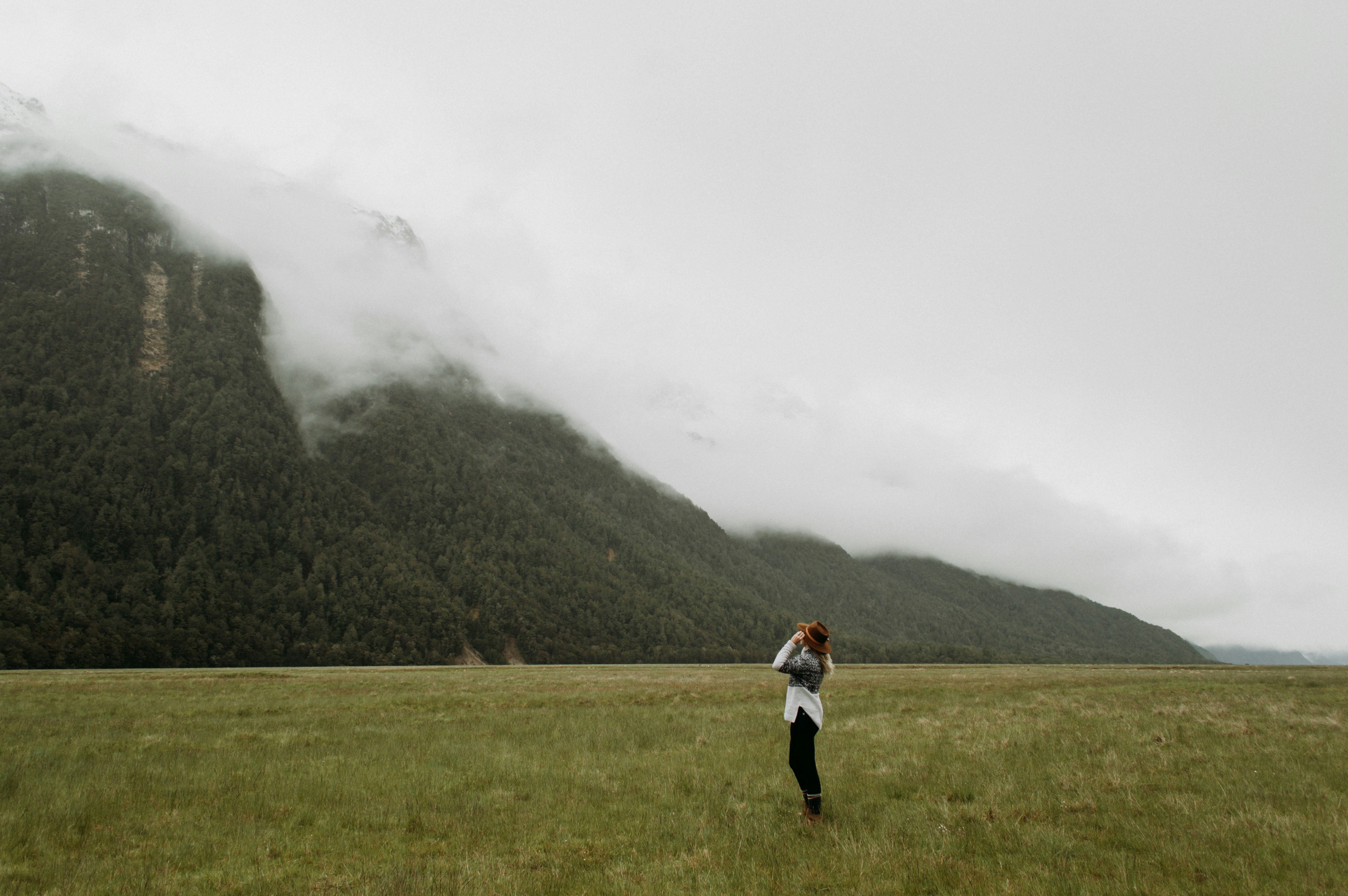Persona in camicia bianca in piedi sul campo di erba verde durante il giorno