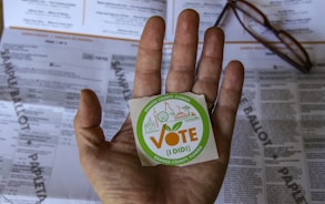 person holding green and white round plastic container